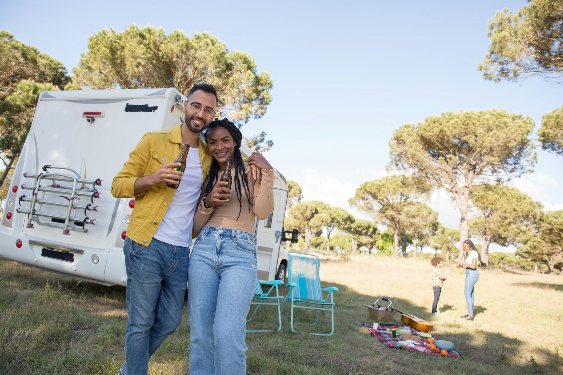 A man and a woman are standing in front of a camper van.