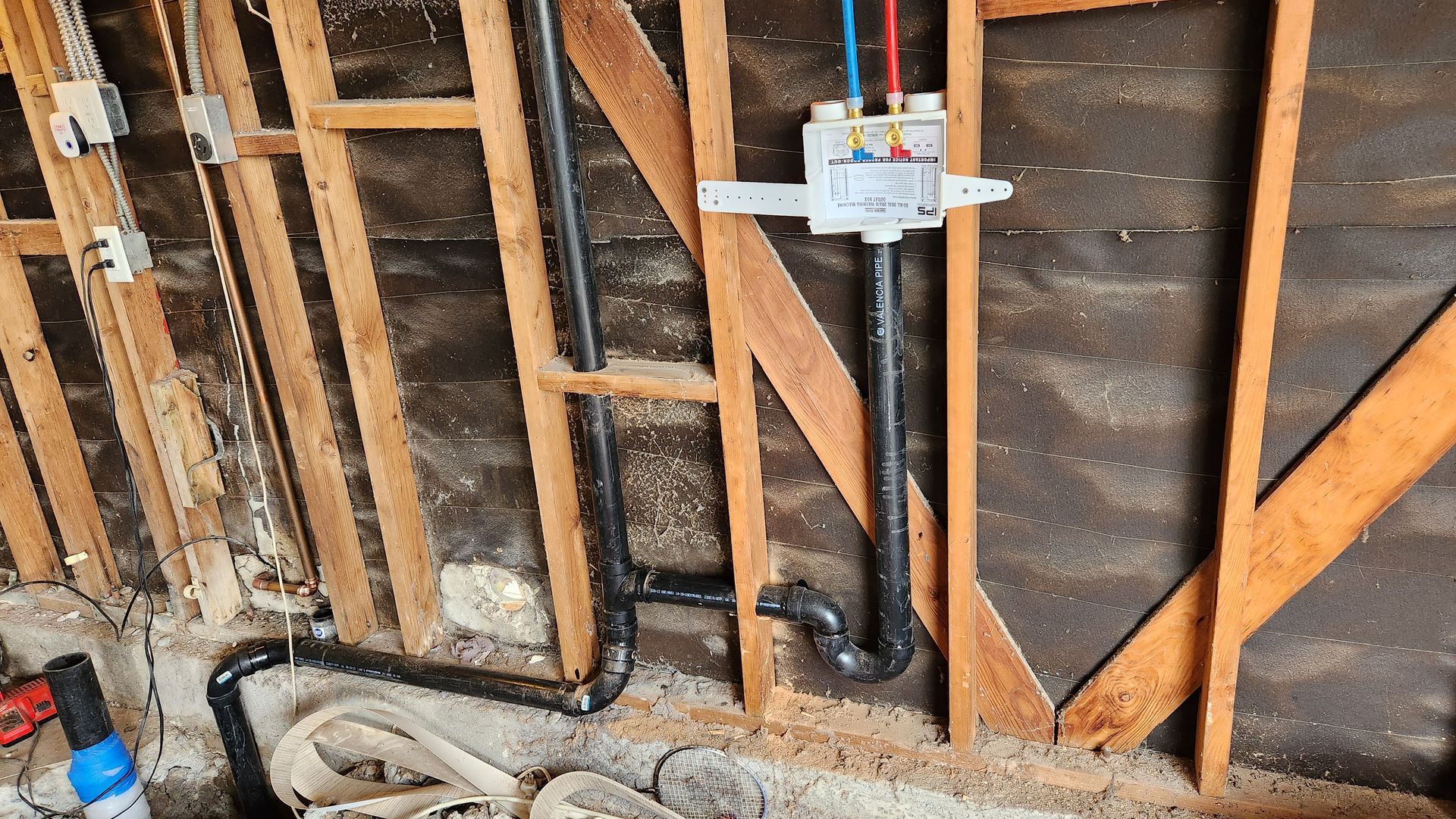 A wooden wall with a bunch of pipes coming out of it