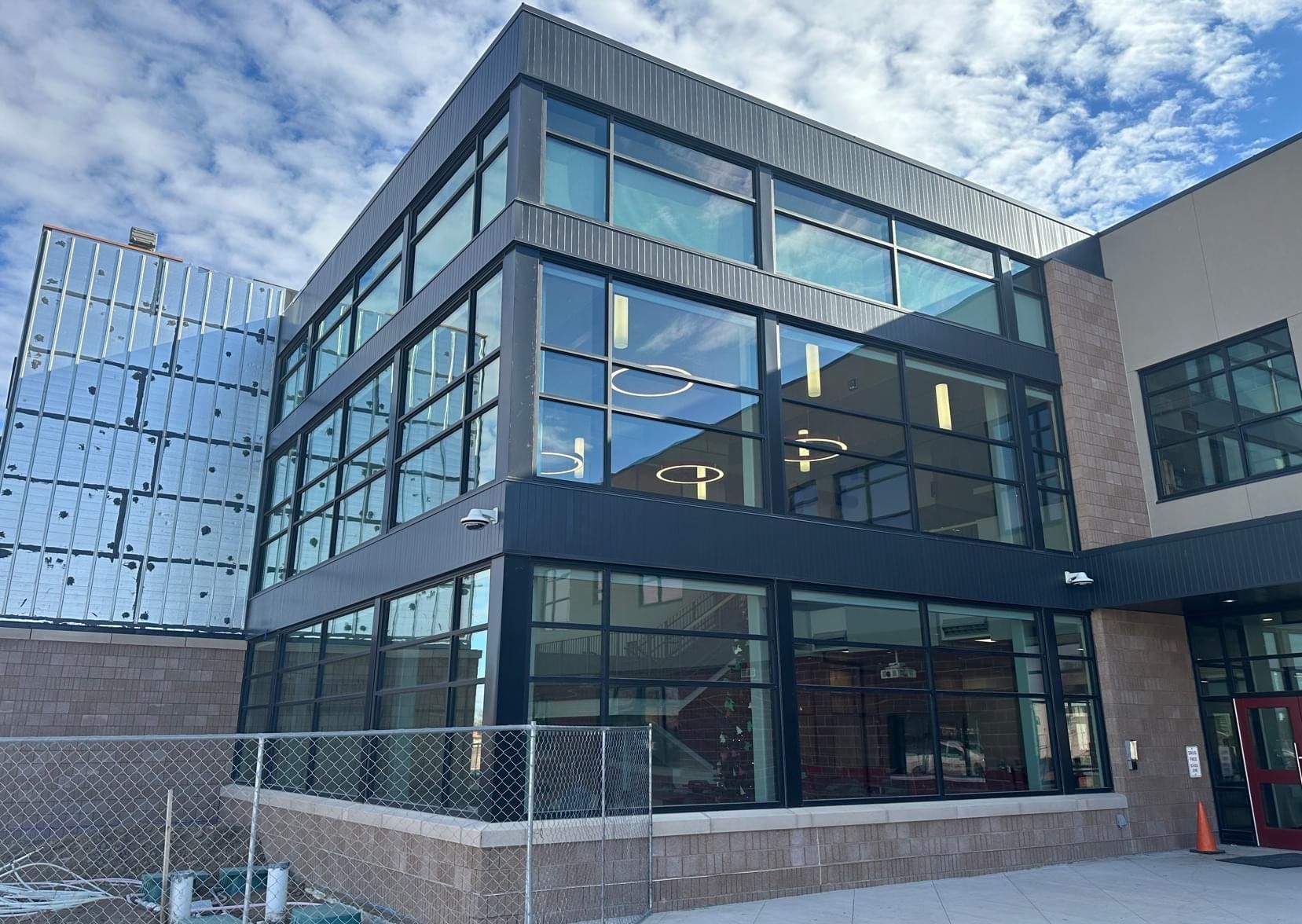 Modern building with dark metal frame and large glass windows; exterior shot.