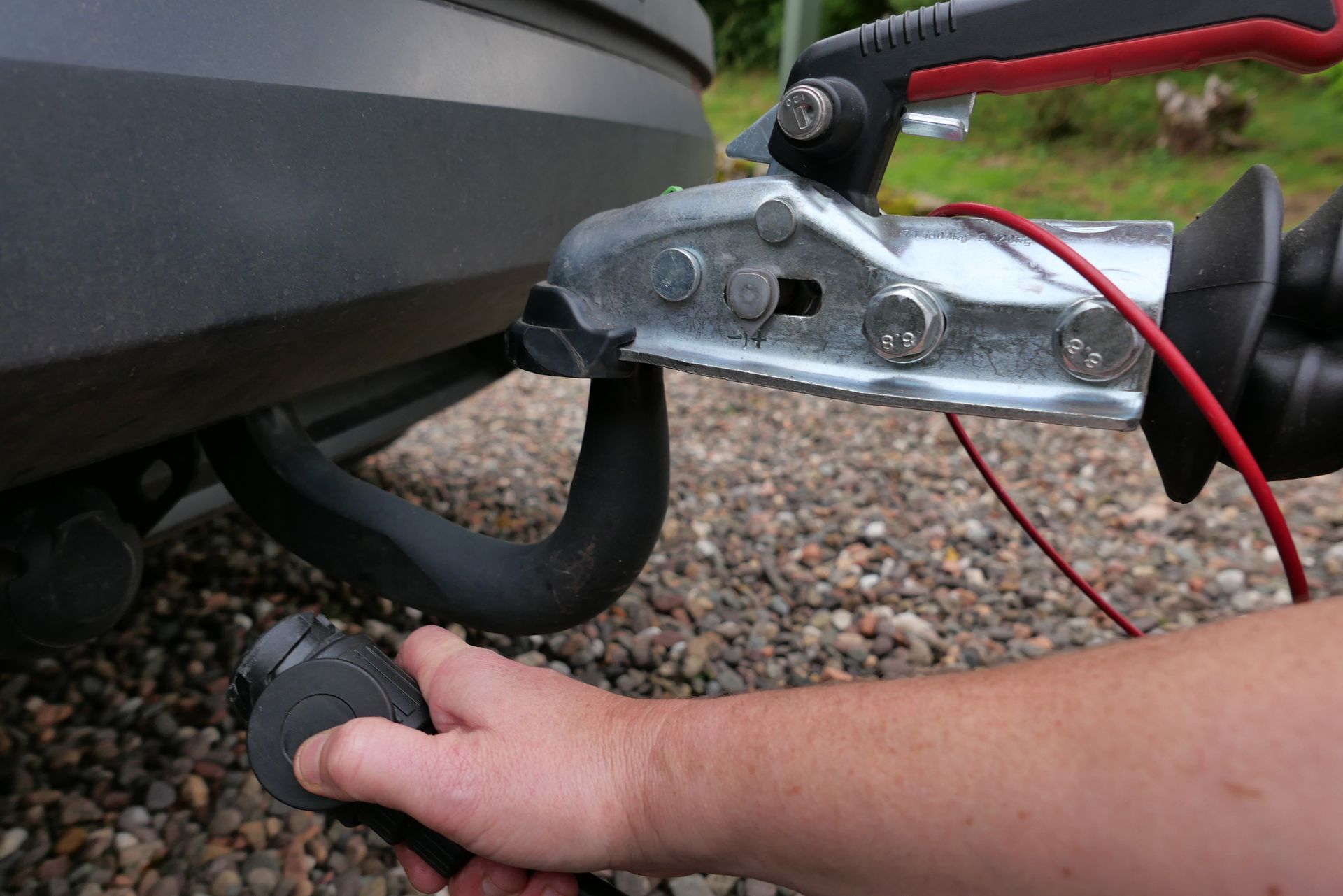Plugging in the electric cable between the caravan and the car for towing.