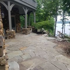 A stone patio with a view of a lake