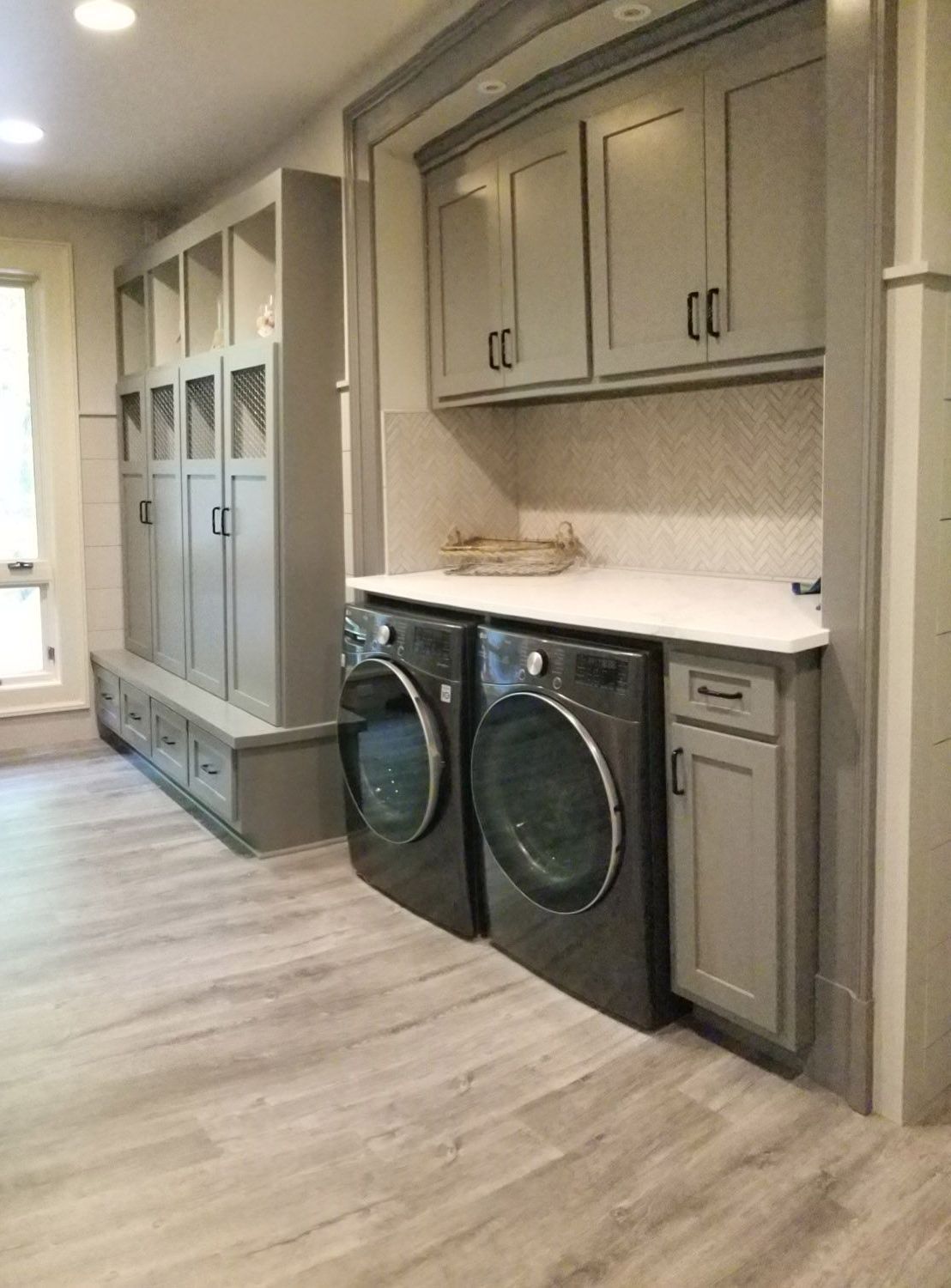 A laundry room with a washer and dryer and lots of cabinets.