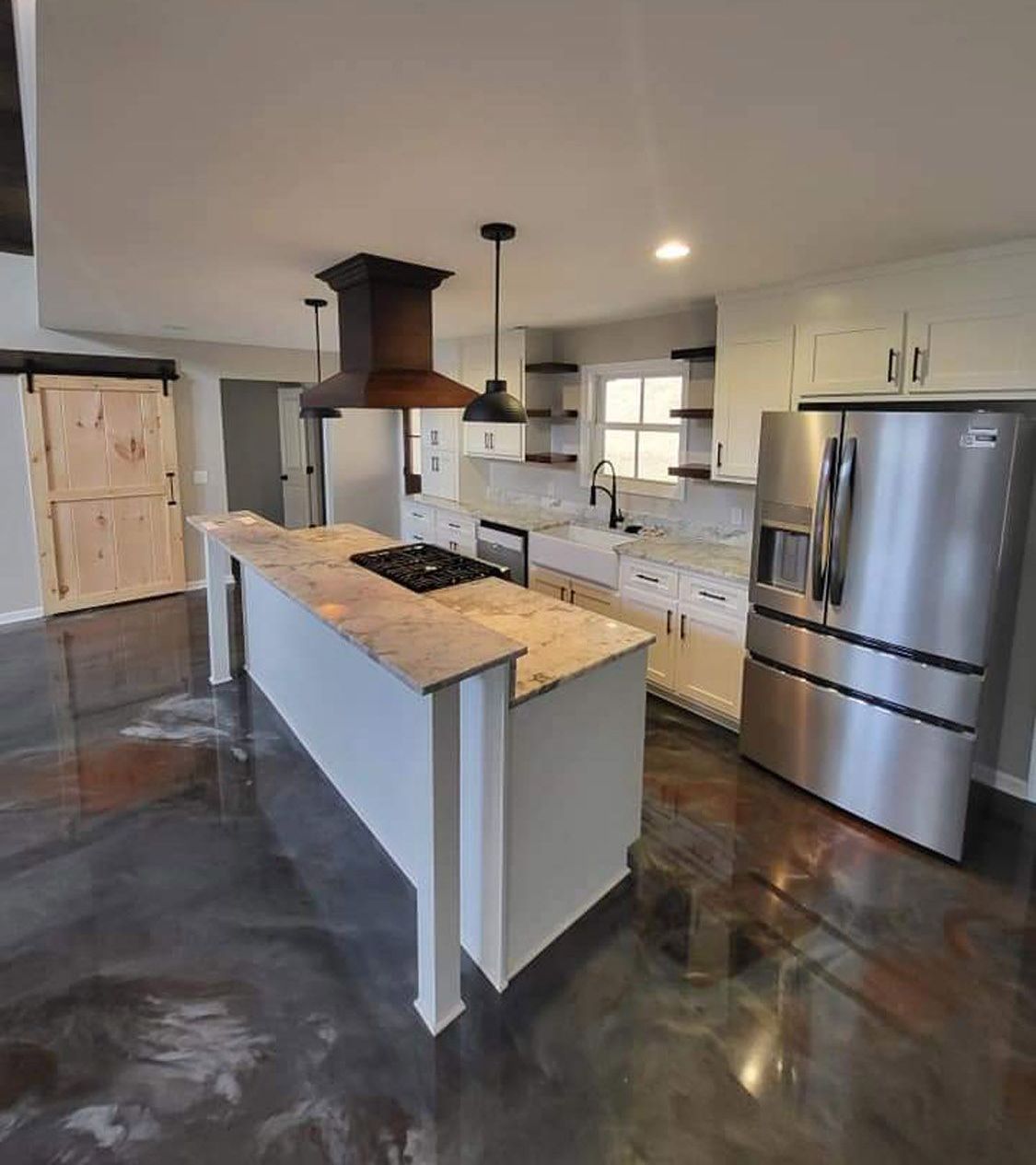 A kitchen with a large island and stainless steel appliances