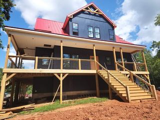 A large house with a red roof is being built on stilts.