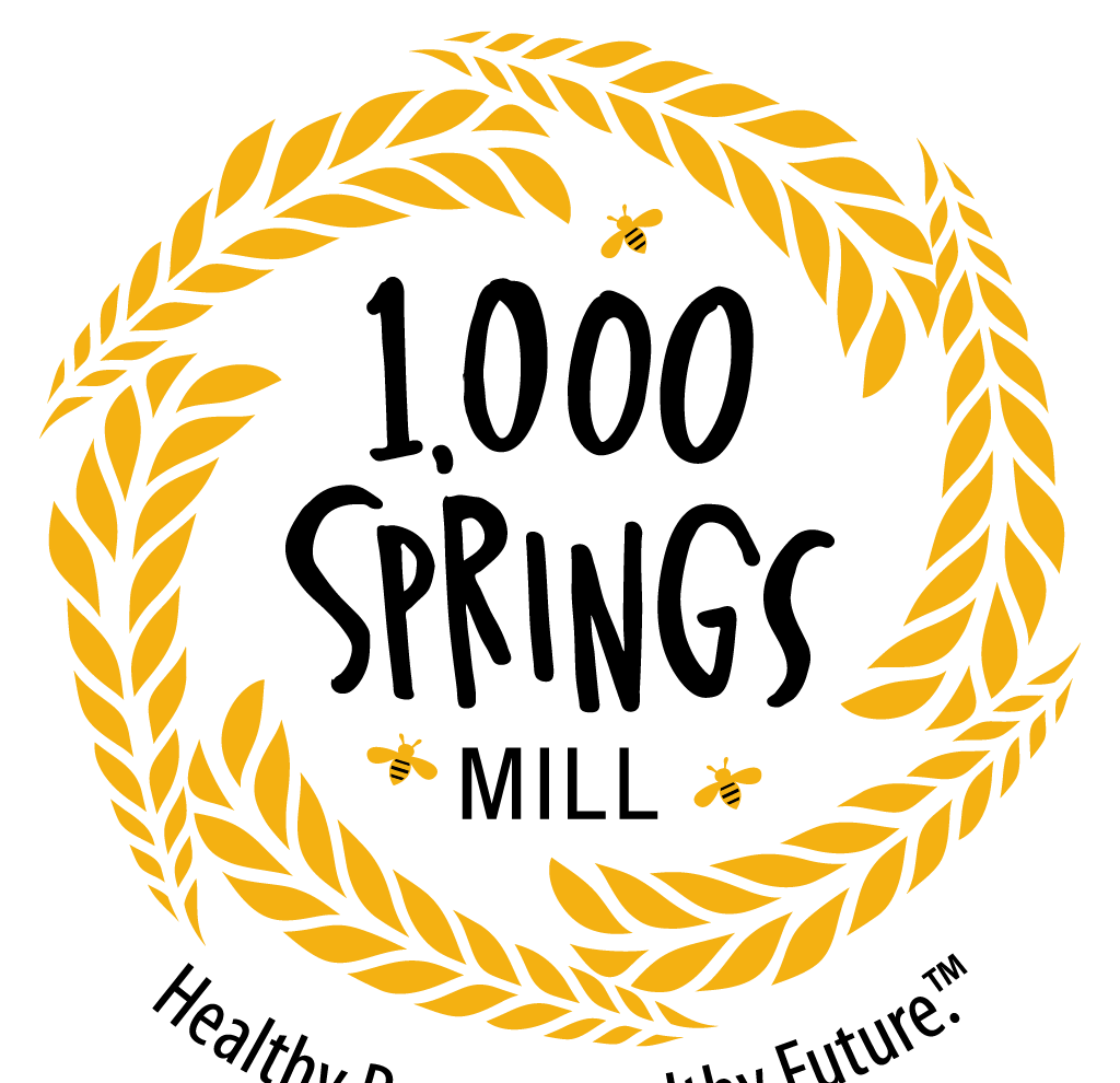 A logo for the 1,000 springs mill with a wreath of wheat and bees.