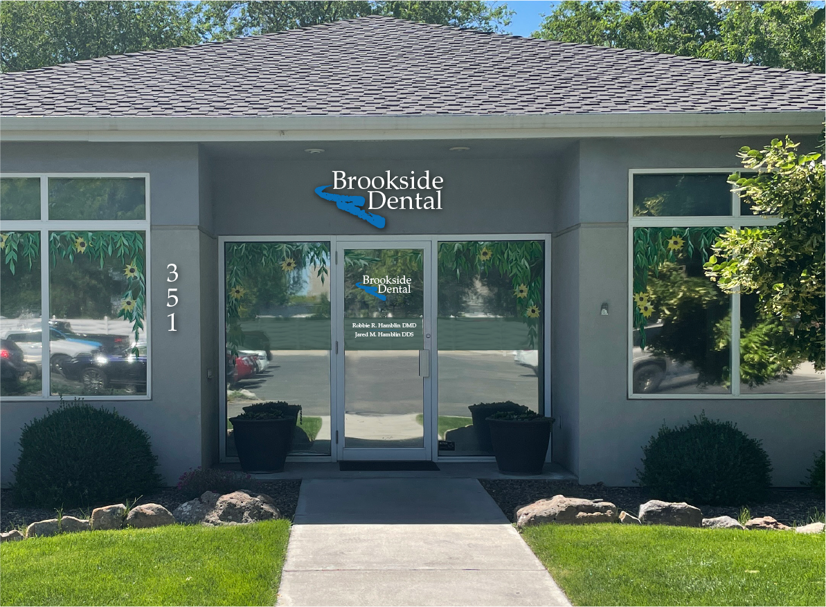 The front of a dental office with a walkway leading to it.