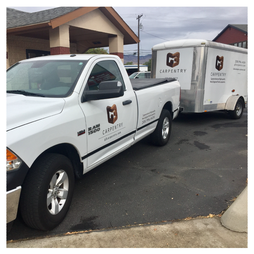 A white ram truck is parked next to a trailer