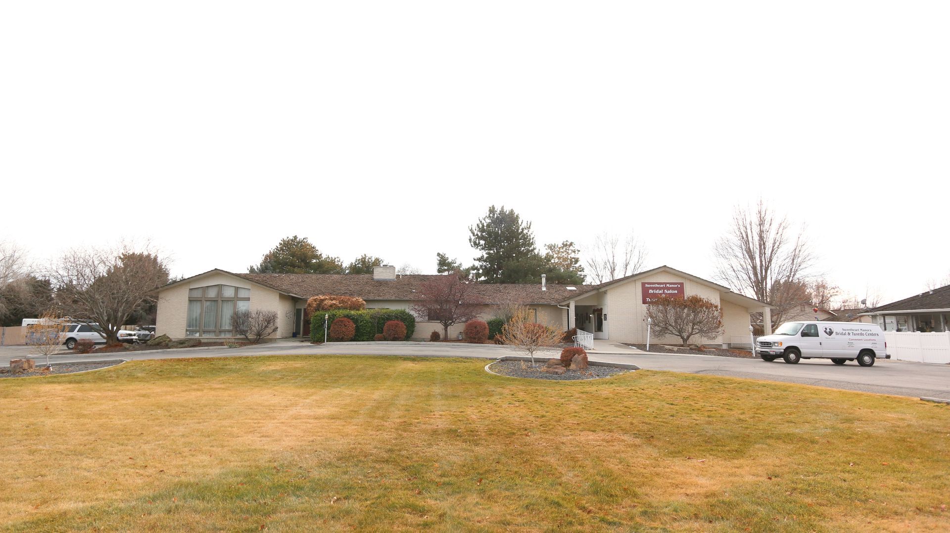 A white van is parked in front of a house.