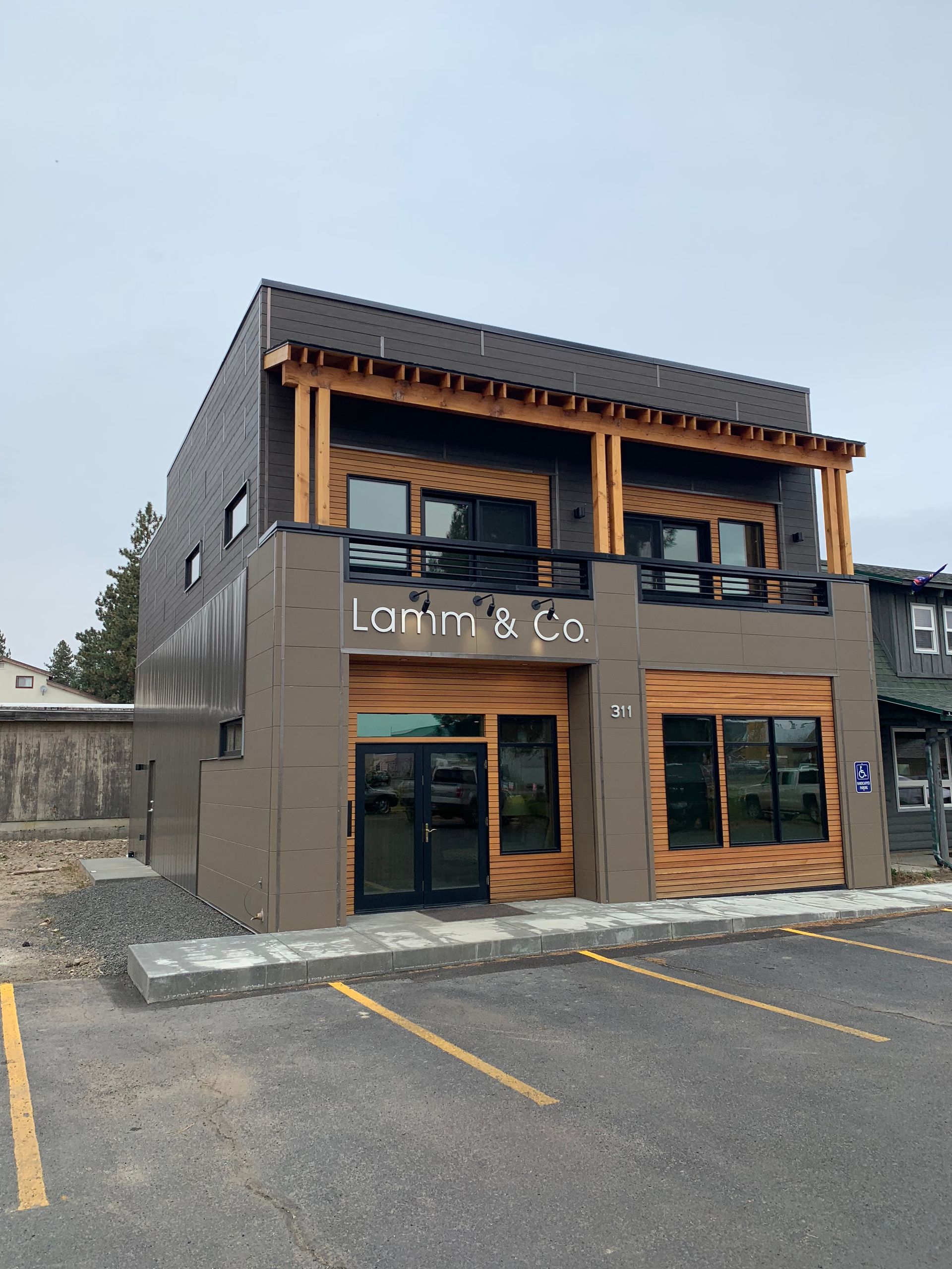 A large building with a lot of windows and a parking lot in front of it.