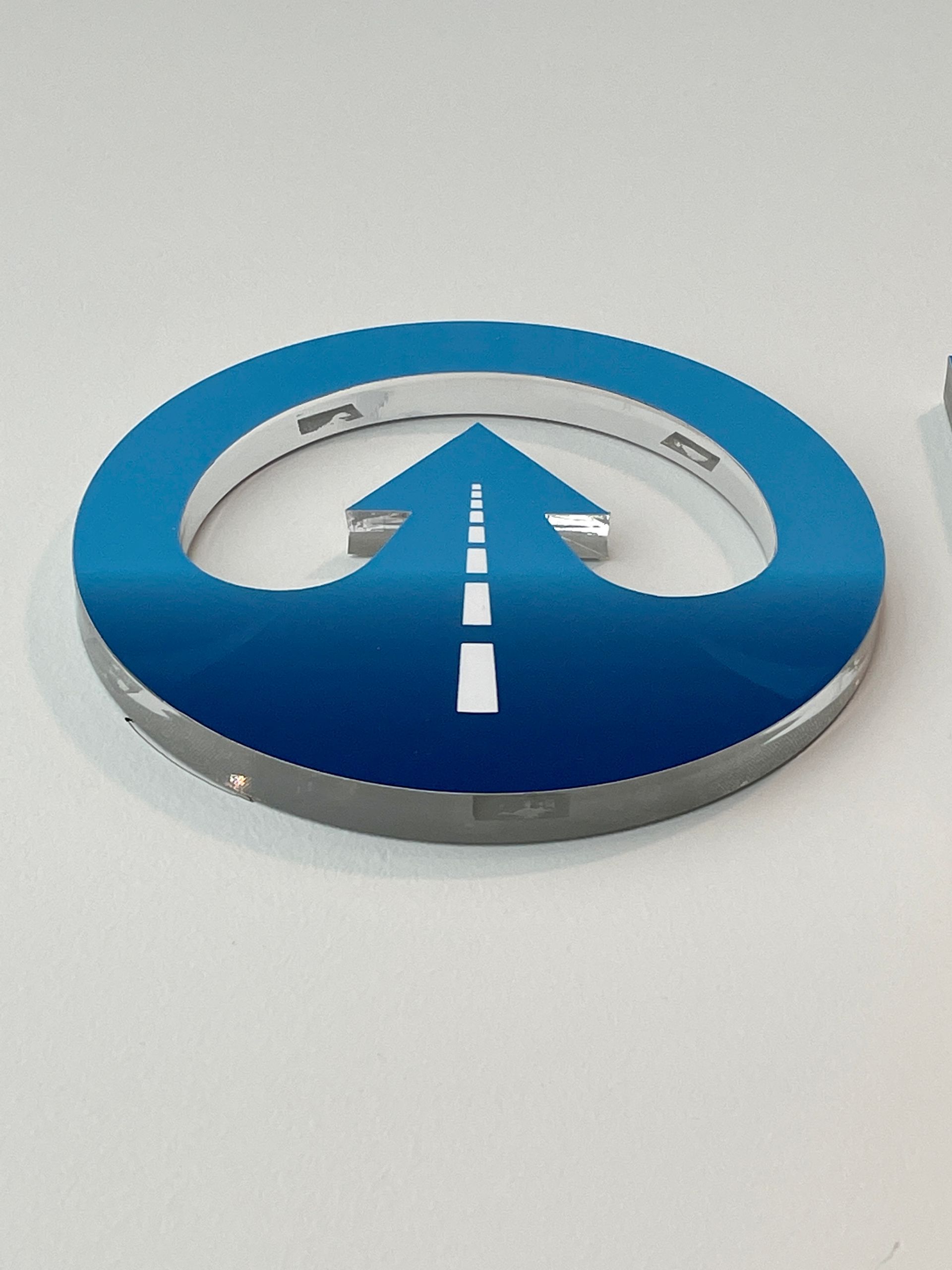 A blue circle with a white arrow pointing up