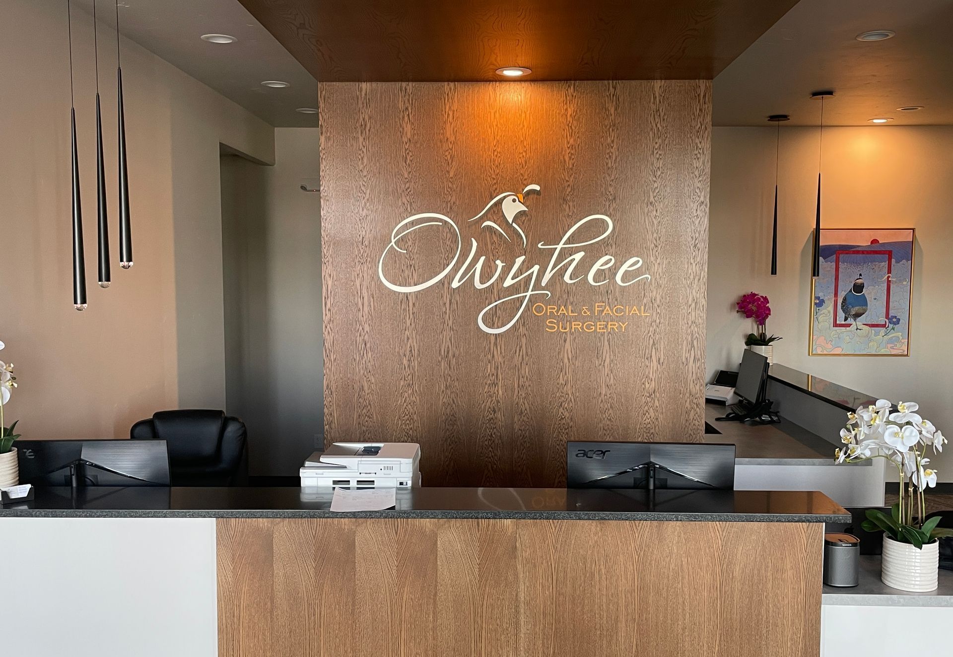 A hotel lobby with a wooden wall and a reception desk.