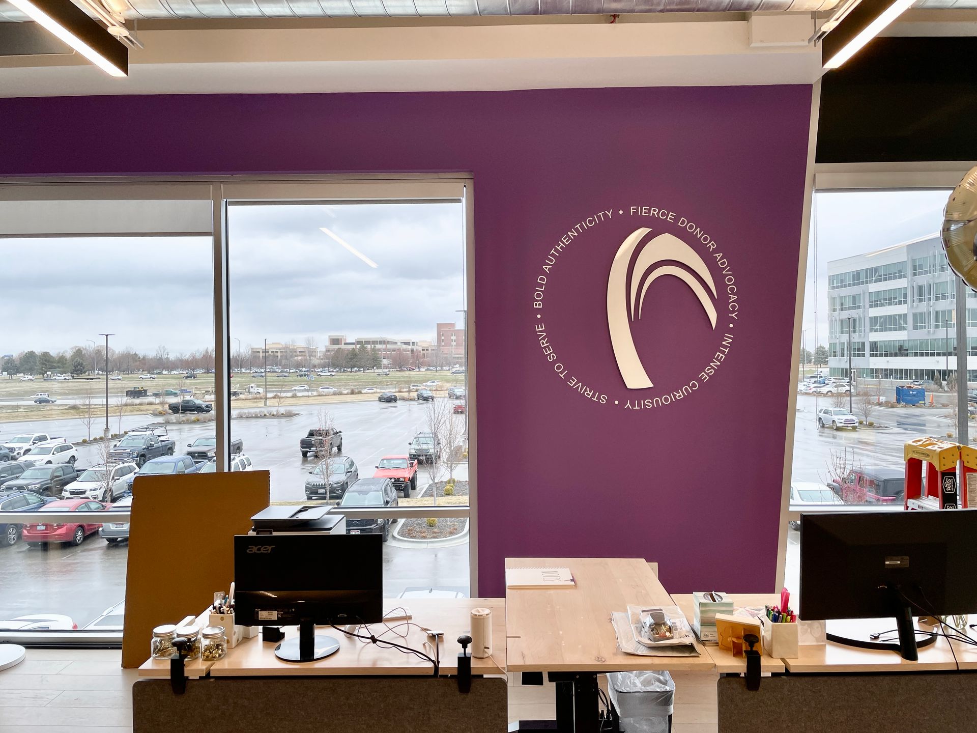 An office with a purple wall and a logo on it