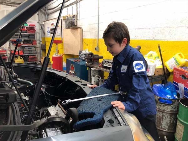 A Child Learns How to Repair a Vehicle at Golden Gears Automotive Inc - Rockville Auto Repair