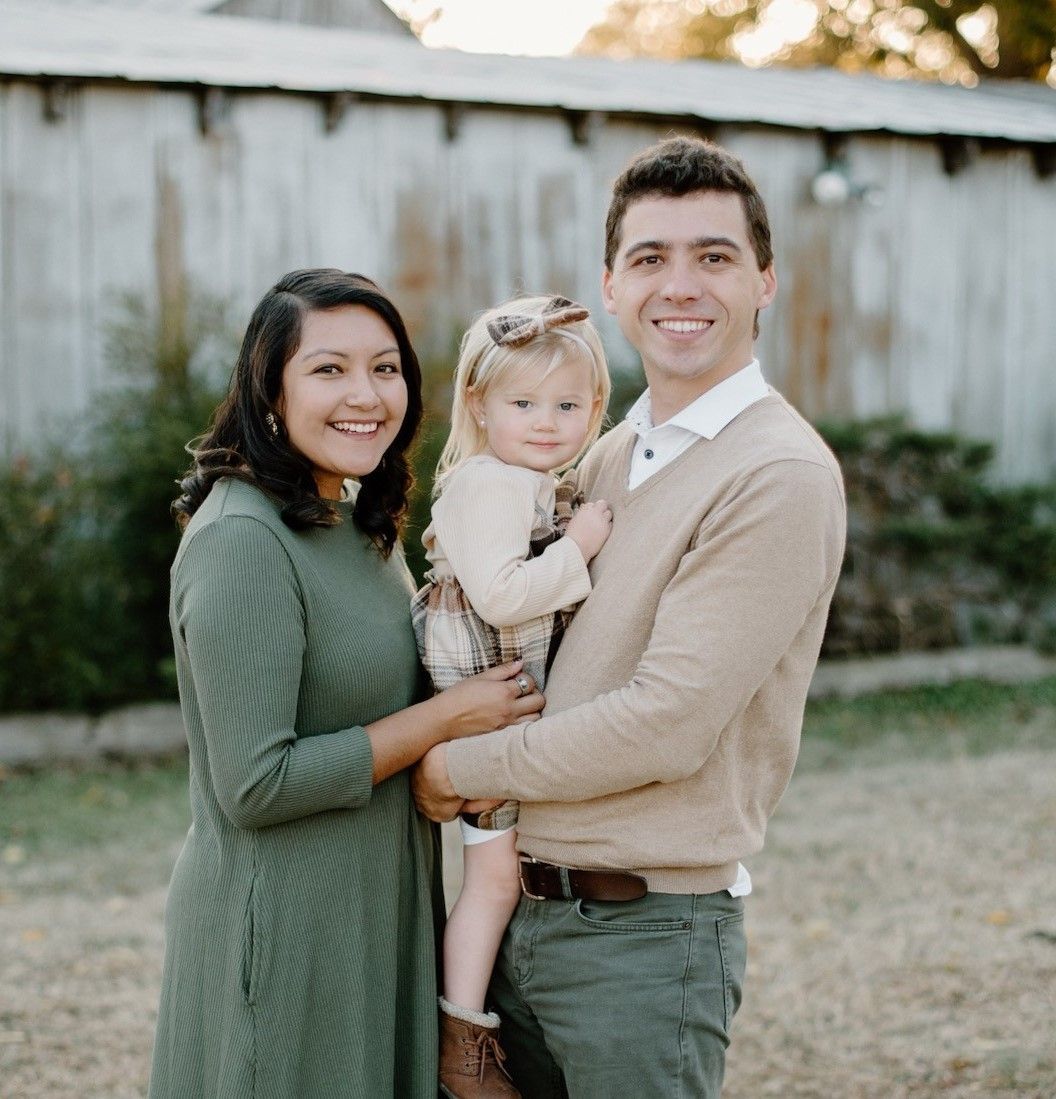 A man and woman are holding a little girl in their arms. A man and woman are holding a little girl in their arms.