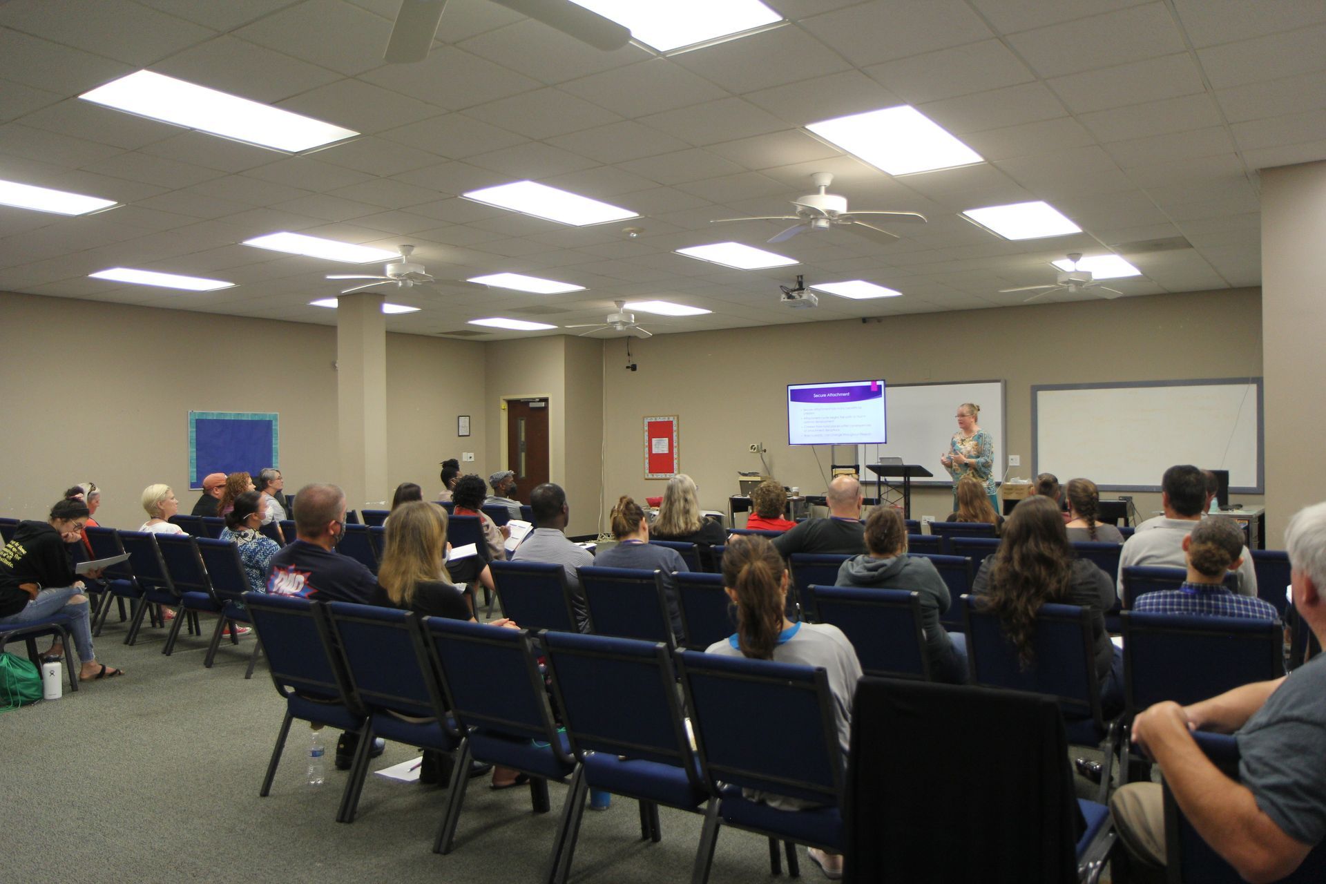 A group of people are sitting in chairs in a large room.