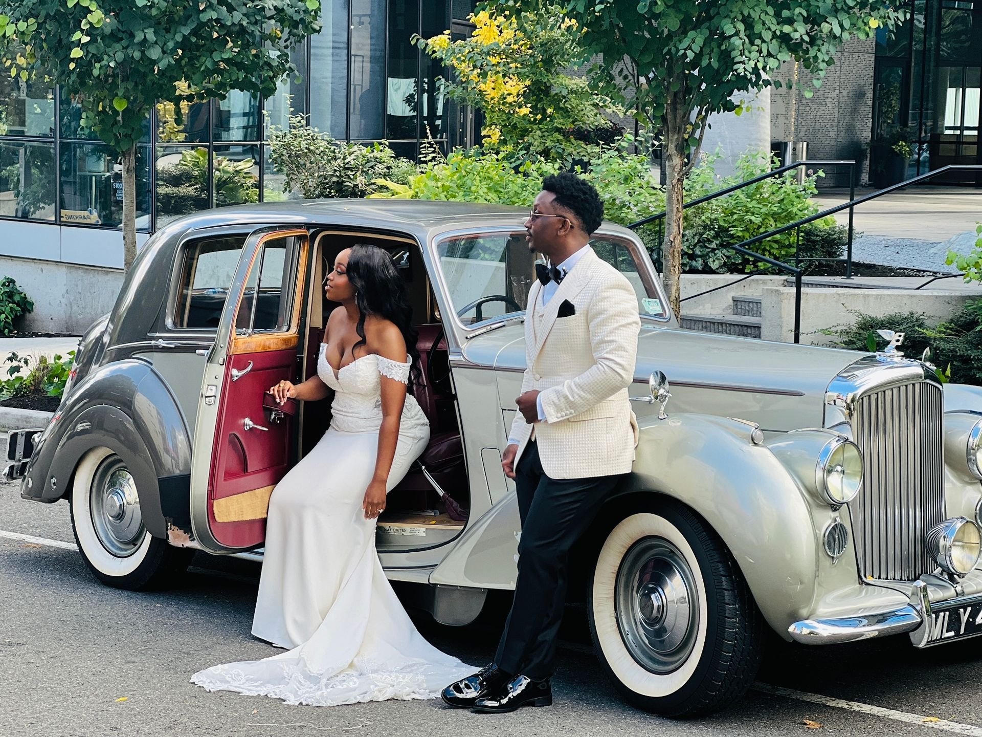 Close-up of a classic silver car with dual round headlights and chrome accents.