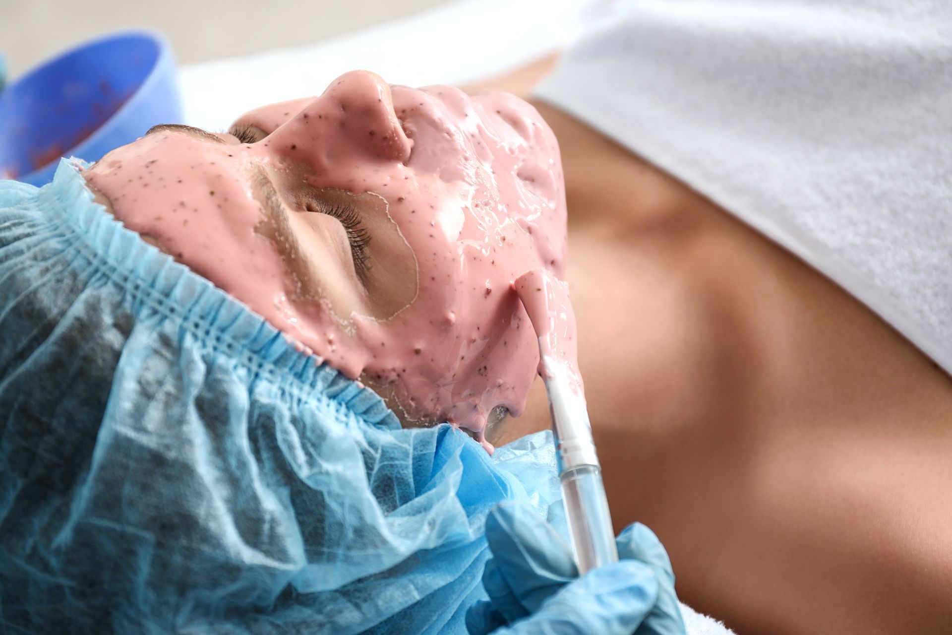 A woman is laying on a bed with a mask on her face.