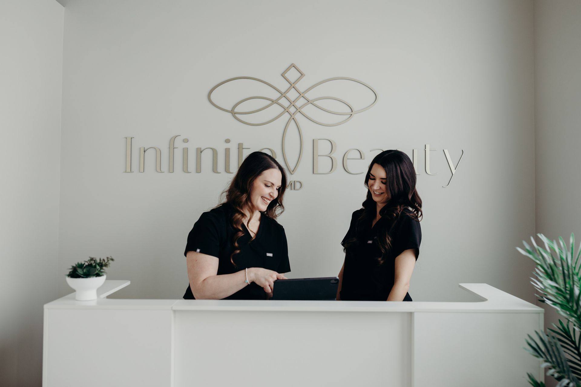 Two women are standing at a reception desk in a beauty salon.