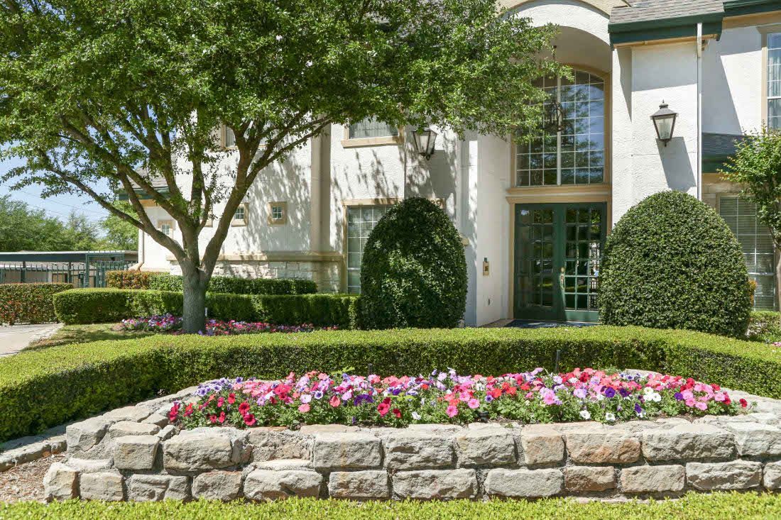 Exterior view of a property entrance with landscaping and flowers