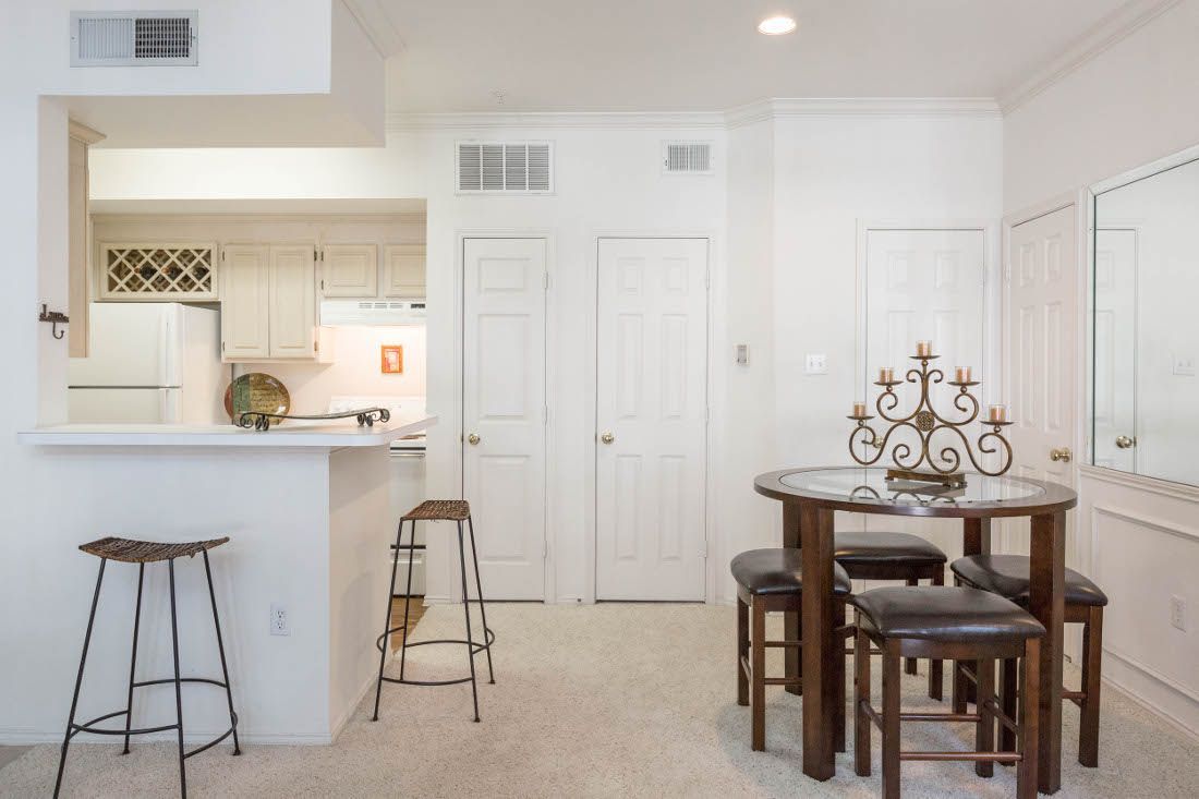 Bright kitchen and dining area with a round table and bar stools
