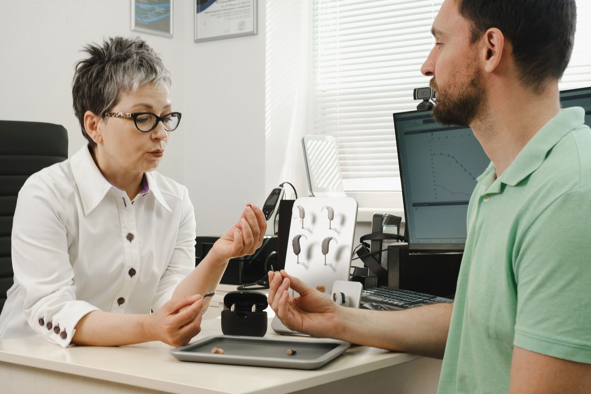 A doctor is consulting a patient for selecting a hearing aid.