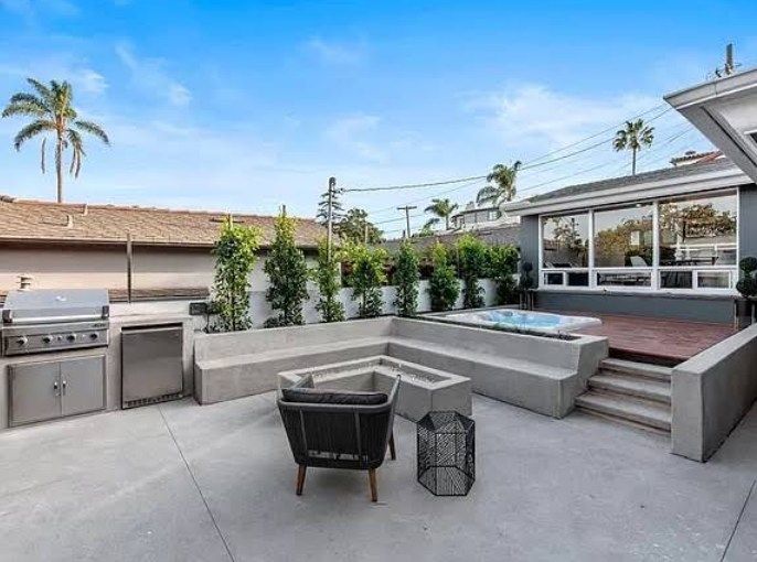 Backyard patio with grill, seating, raised planters, and a hot tub.