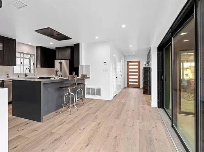 Modern luxury kitchen with dark cabinets and large sliding glass door.