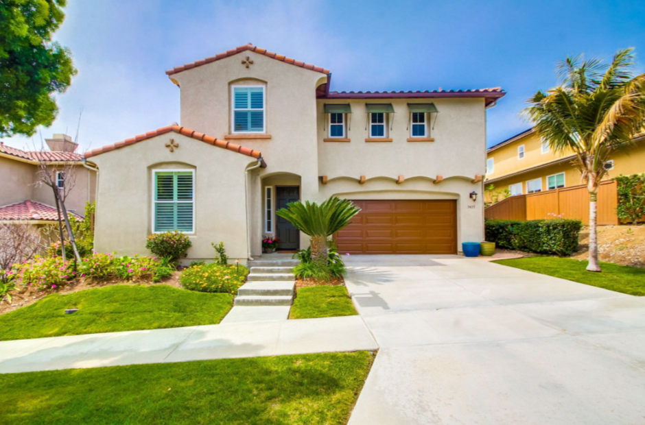 Charming single story house exterior with white stucco and tiled roof.
