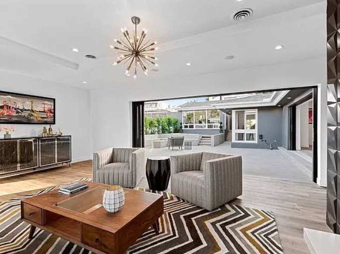 Open concept living room and dining area with modern chandelier.