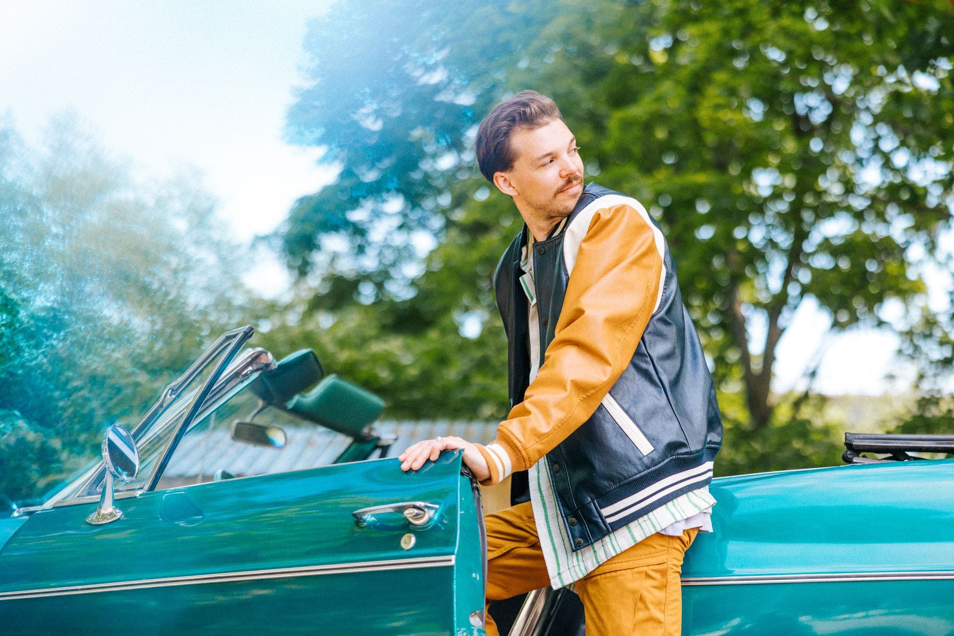 Man sitting in car with closing convertible top, showcasing convertible vehicle top replacement. Man sitting in car with closing convertible top, showcasing convertible vehicle top replacement.