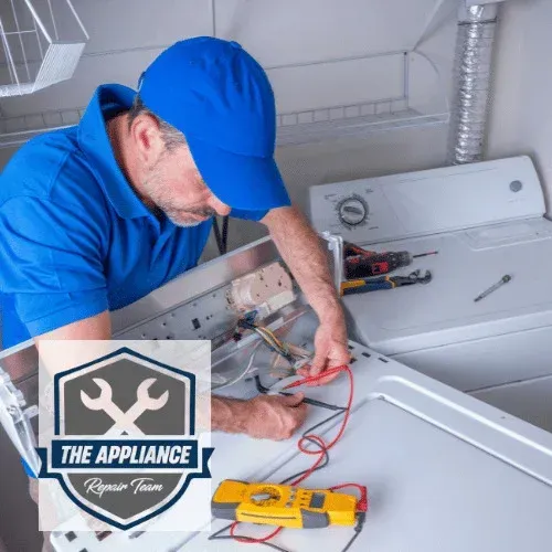 A technician in blue cap tests a dryer with a multimeter. White dryer in a laundry room, logo present.