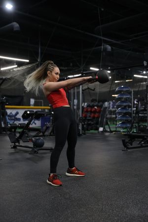A woman is squatting down with a rope in her hand