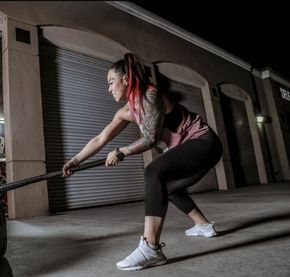 A woman is squatting down with a rope in her hand