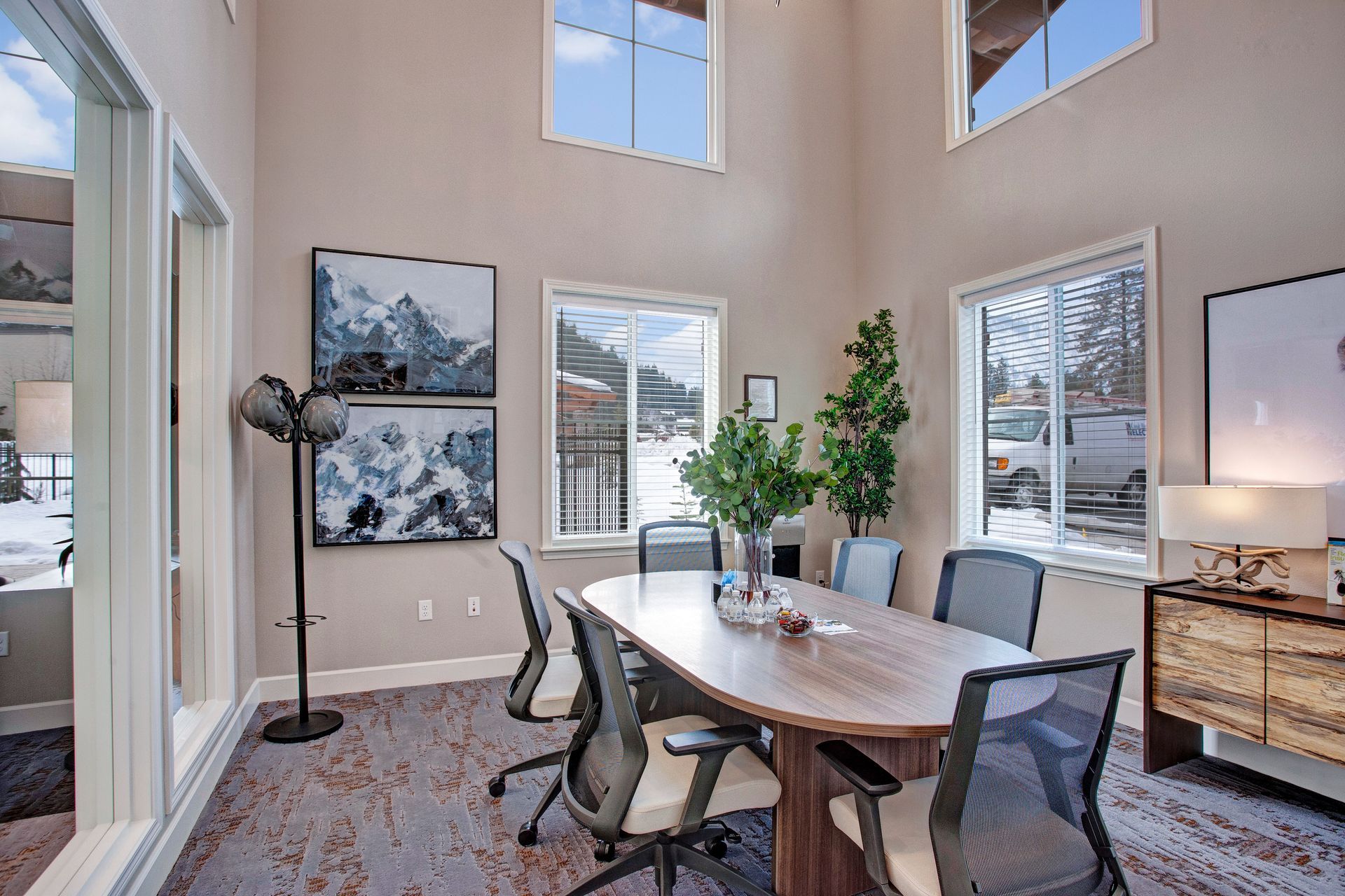 A conference room with a table and chairs and a lot of windows.