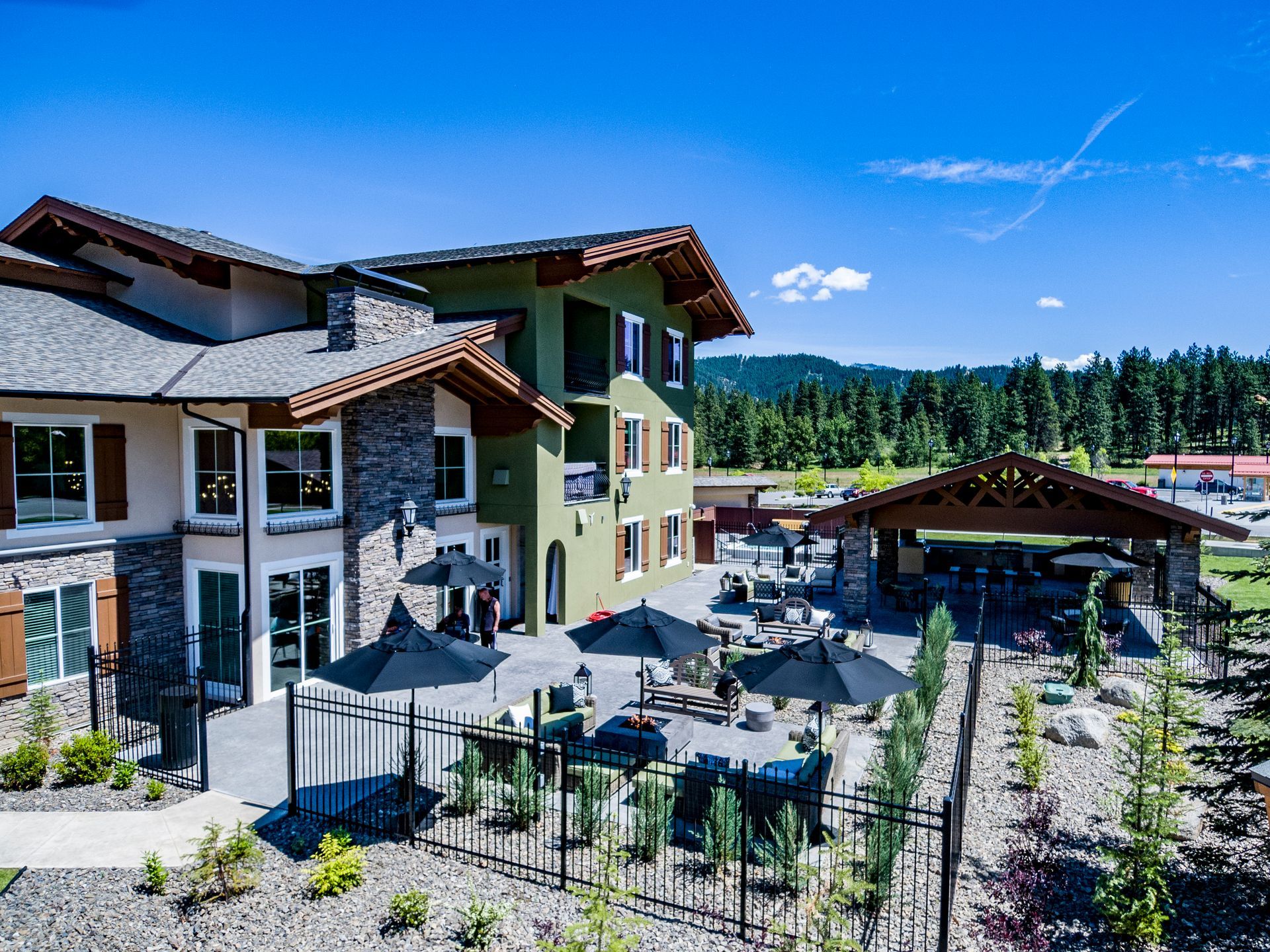 A large house with a patio and umbrellas in front of it