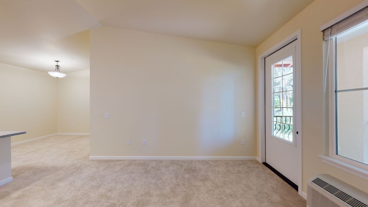 An empty room with a sliding glass door and a window.