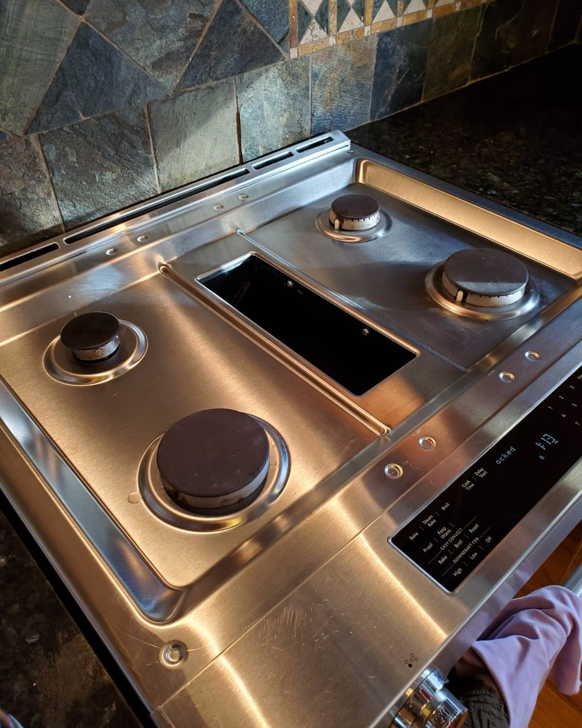 A close up of a stainless steel stove top oven in a kitchen.