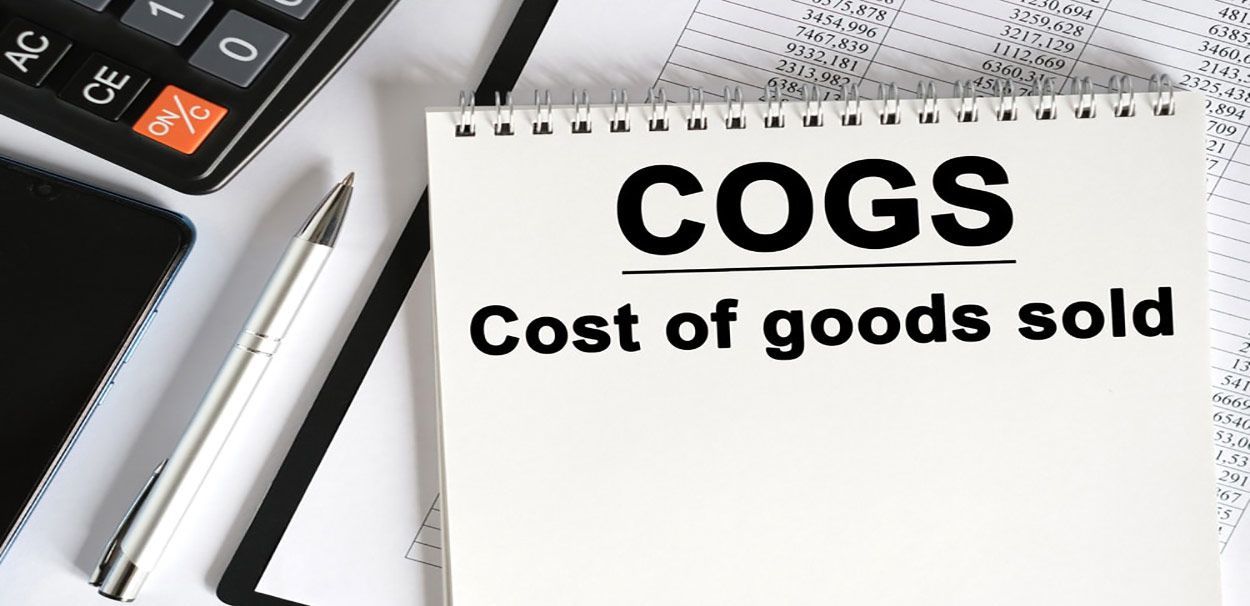 A notebook with the words cogs cost of goods sold written on it.