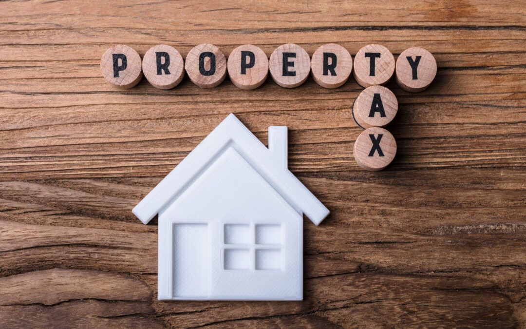 The word property is written on a wooden table next to a house.