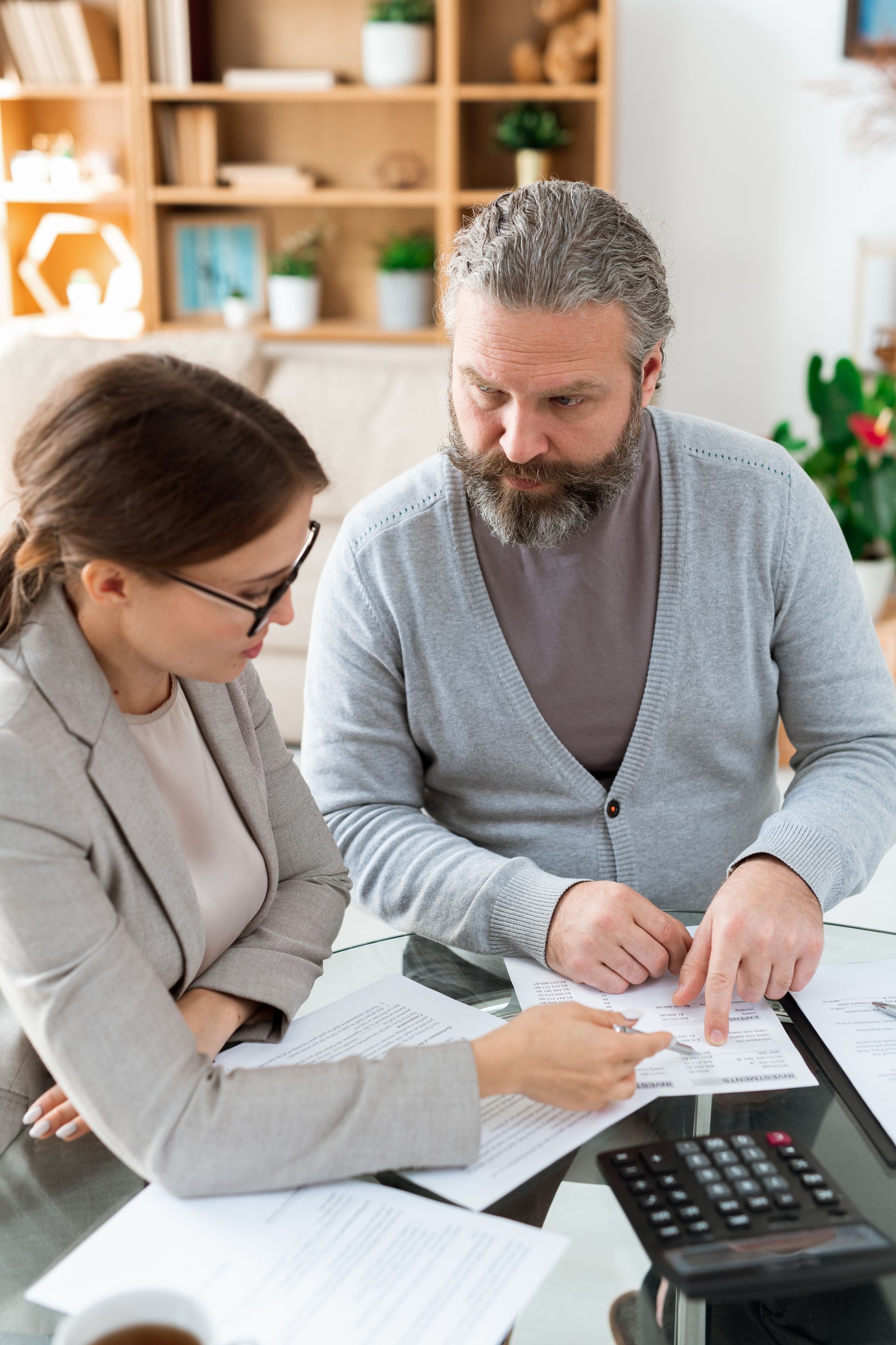 A man and a woman are sitting at a table looking at papers.