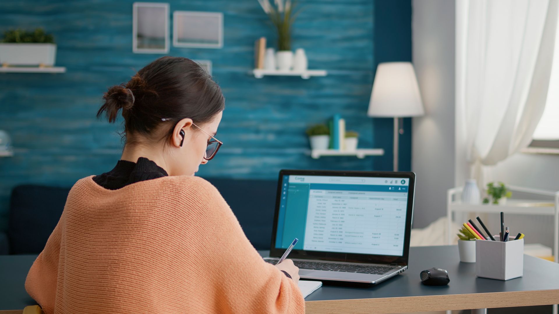 A woman is sitting at a desk using a laptop computer.