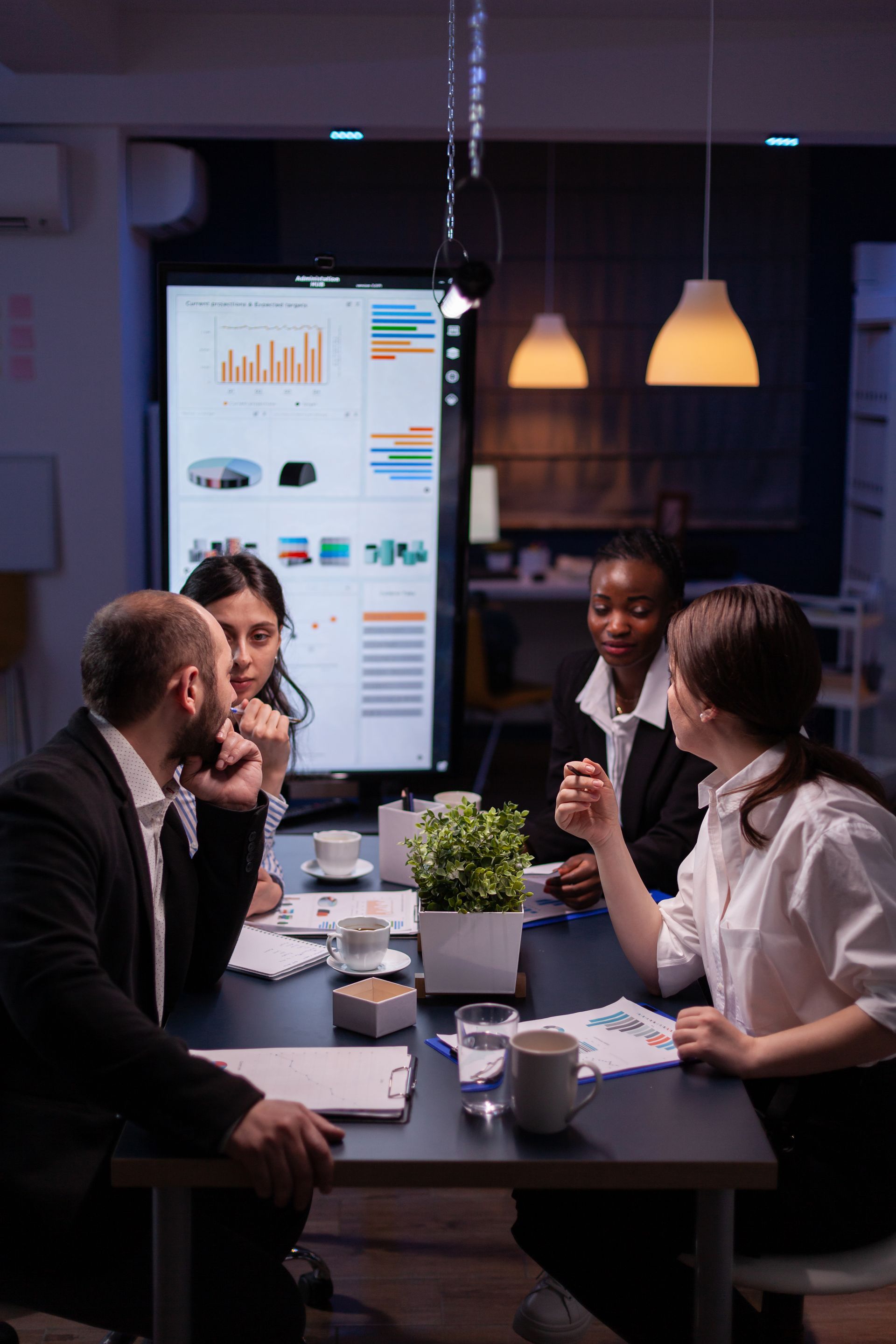 A group of people are sitting around a table having a meeting.