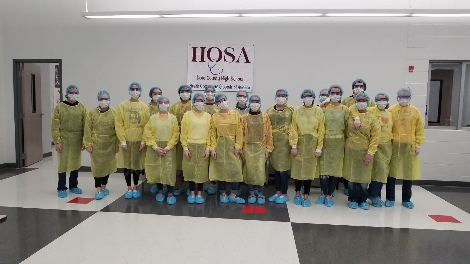 a group of people wearing safety gowns and masks are posing for a picture .
