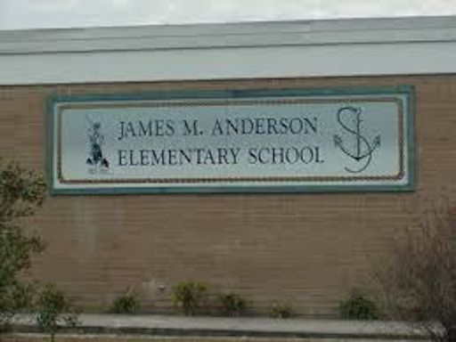 a sign for james m. anderson elementary school is on the side of a brick building .