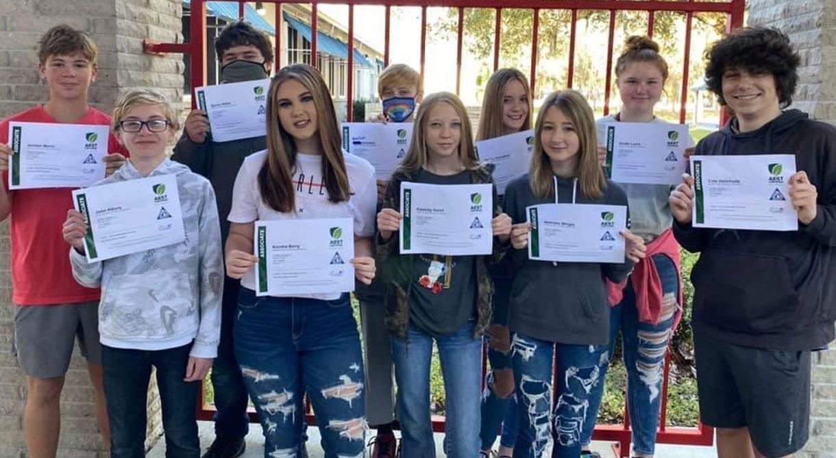 a group of young people are standing next to each other holding certificates .