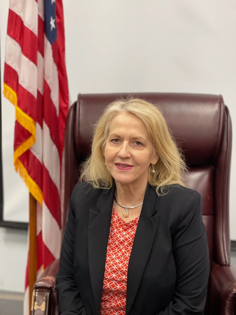 a woman is sitting in a chair in front of an american flag .