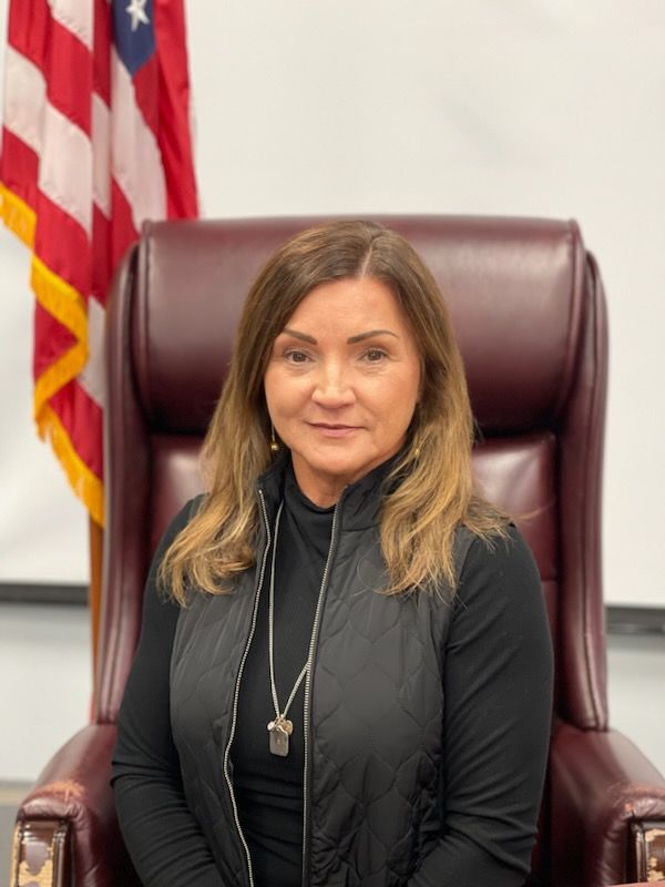 a woman is sitting in a chair in front of an american flag .