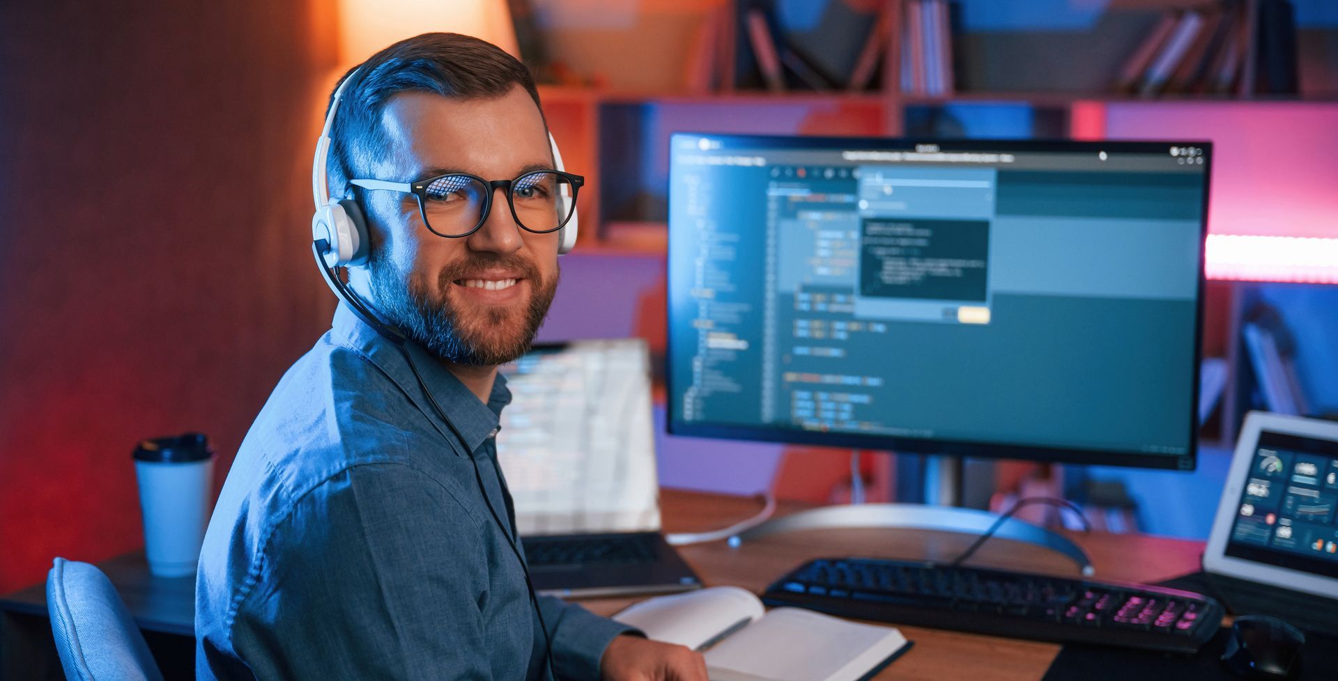 a man wearing headphones is sitting in front of a computer monitor