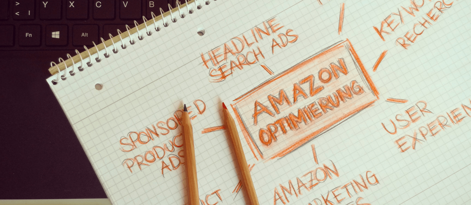 A notebook with two pencils on top of it and the word amazon written on it.
