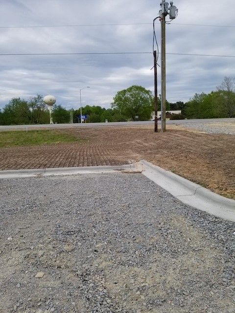 A gravel road with a water tower in the background